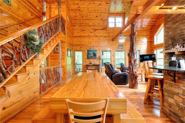 dining area with stairway, high vaulted ceiling, wood walls, wood ceiling, and wood finished floors
