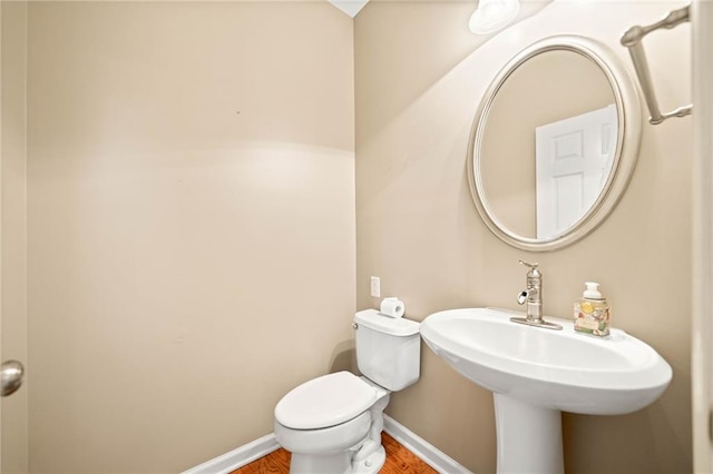 bathroom featuring hardwood / wood-style floors, toilet, and sink