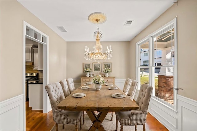 dining area with dark hardwood / wood-style flooring and a notable chandelier