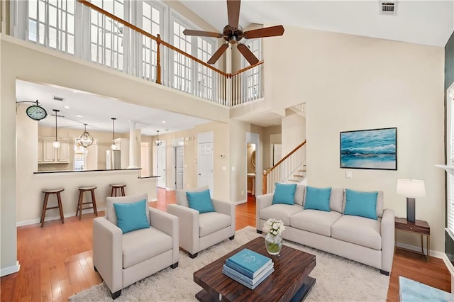 living room featuring ceiling fan, plenty of natural light, high vaulted ceiling, and light hardwood / wood-style floors