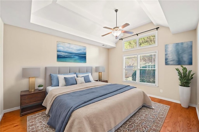 bedroom with vaulted ceiling with beams, ceiling fan, and light wood-type flooring