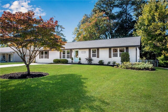 single story home featuring a front lawn