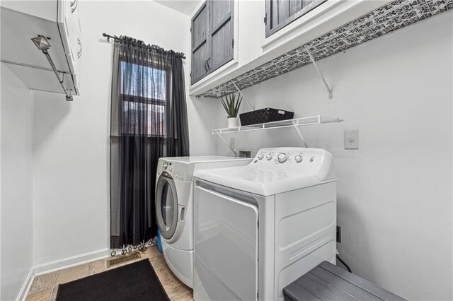 laundry area with cabinets and washing machine and clothes dryer