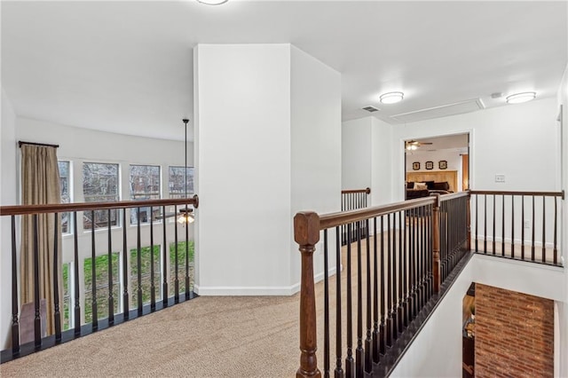 hallway with plenty of natural light and carpet flooring