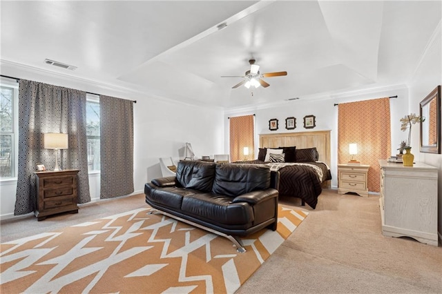 carpeted bedroom with a raised ceiling, crown molding, and ceiling fan