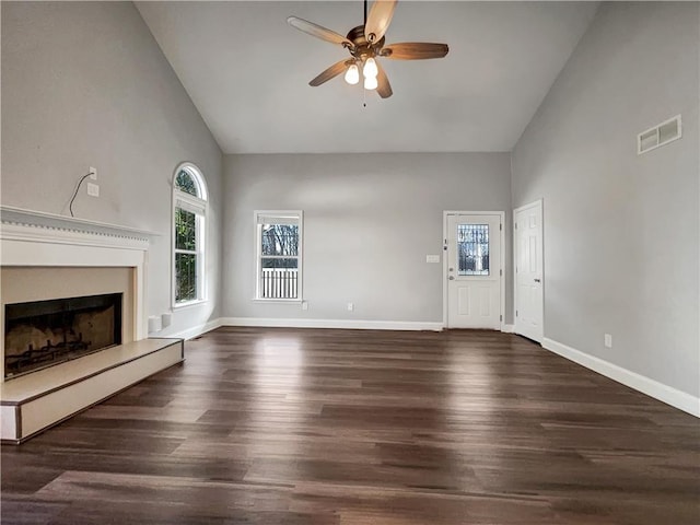 unfurnished living room featuring visible vents, baseboards, a fireplace with raised hearth, and wood finished floors