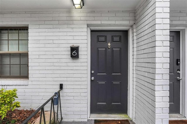 view of exterior entry featuring brick siding