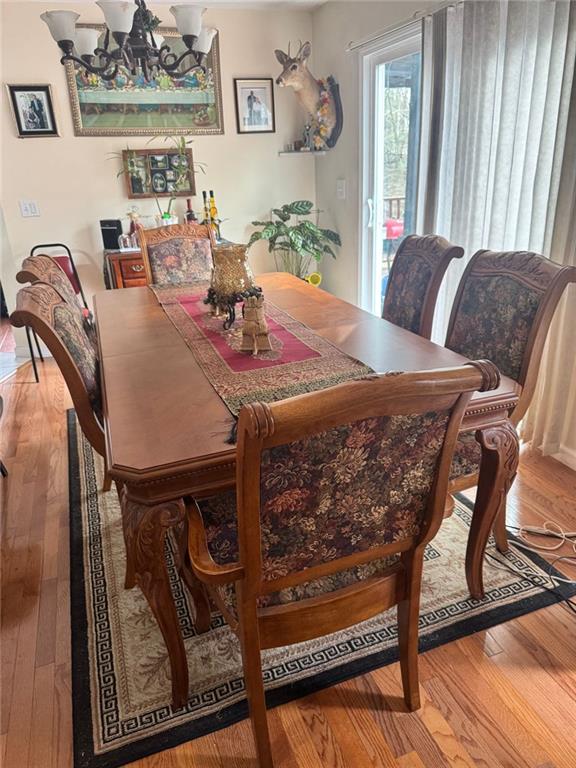dining room with a notable chandelier and wood-type flooring