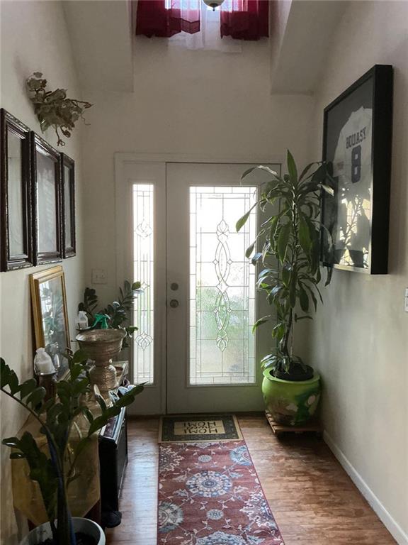 foyer entrance featuring baseboards and wood finished floors
