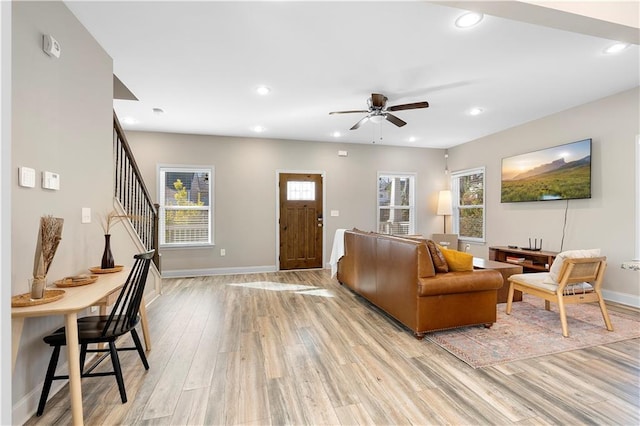 living room with ceiling fan, a healthy amount of sunlight, and light wood-type flooring