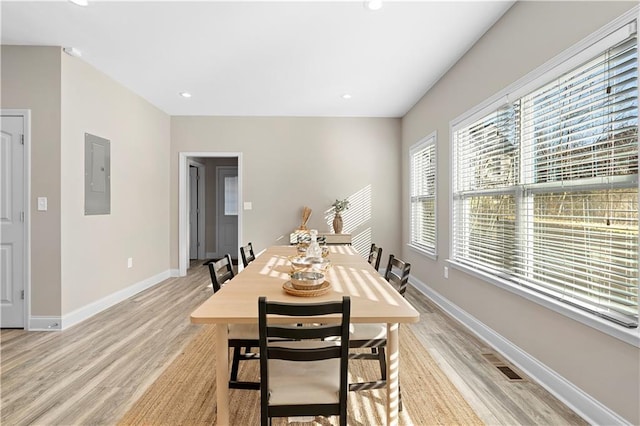 dining area with electric panel and light hardwood / wood-style floors