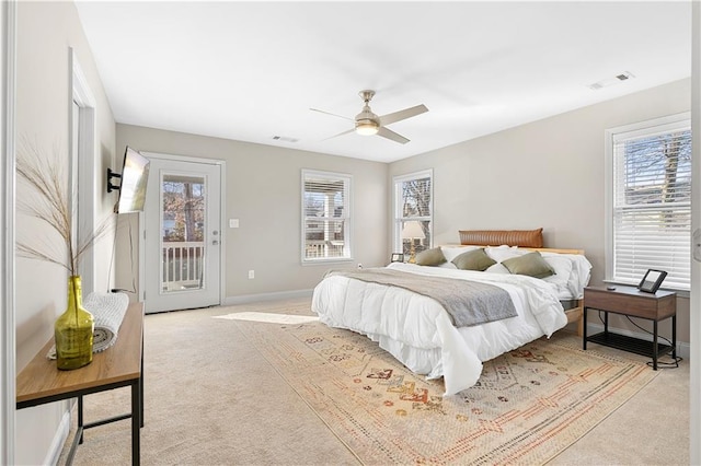 carpeted bedroom featuring multiple windows, access to outside, and ceiling fan