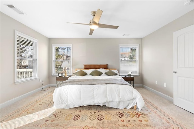 carpeted bedroom with ceiling fan and multiple windows