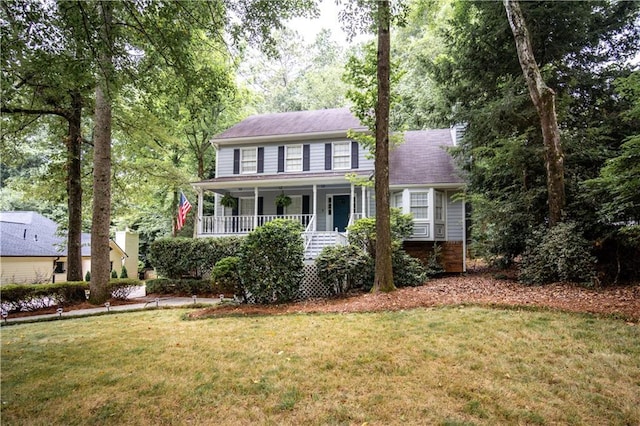 colonial home with covered porch and a front lawn