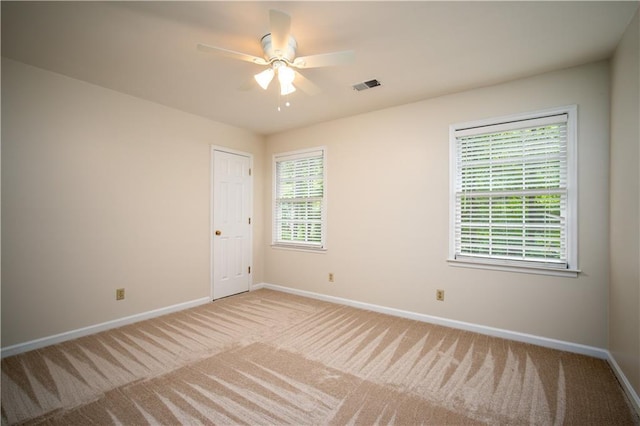 spare room with light carpet and ceiling fan