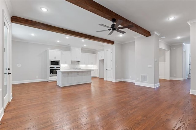 unfurnished living room featuring ceiling fan, ornamental molding, beam ceiling, and light hardwood / wood-style flooring