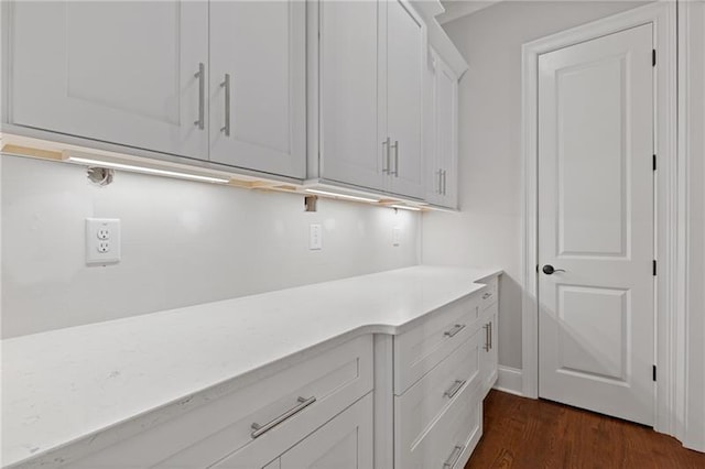 laundry area with dark hardwood / wood-style flooring