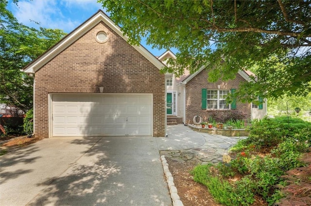 view of front of home featuring brick siding, an attached garage, and concrete driveway