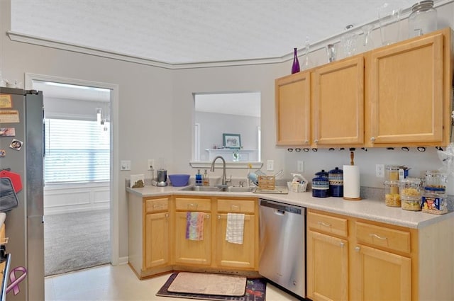 kitchen with a sink, light brown cabinets, stainless steel appliances, and light countertops