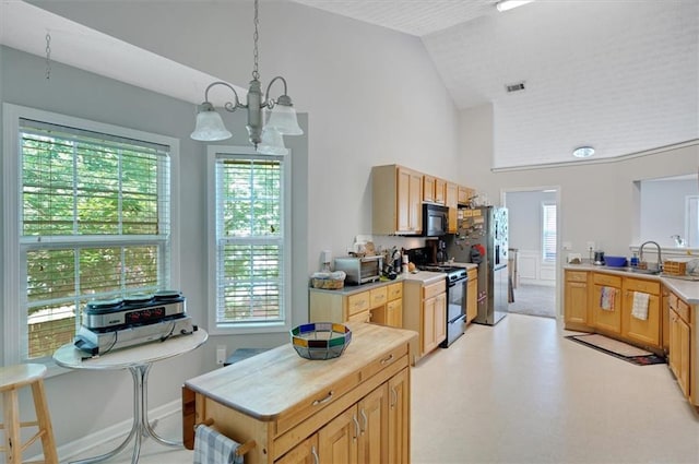 kitchen featuring a sink, black appliances, high vaulted ceiling, and a healthy amount of sunlight