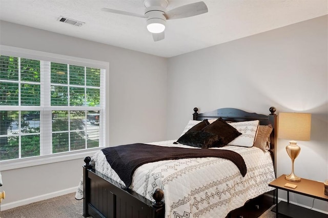 carpeted bedroom with visible vents, a ceiling fan, and baseboards