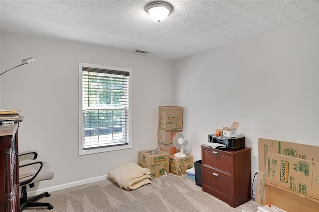 interior space with carpet flooring, a textured ceiling, visible vents, and baseboards