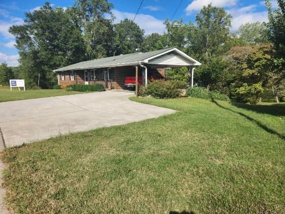 view of front of home featuring a front lawn and a carport