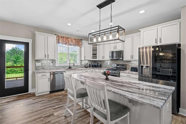 1423 Hillcrest Rd, Bowdon, GA 30108 - kitchen with appliances with stainless steel finishes, a sink, white cabinets, a center island, and a kitchen breakfast bar