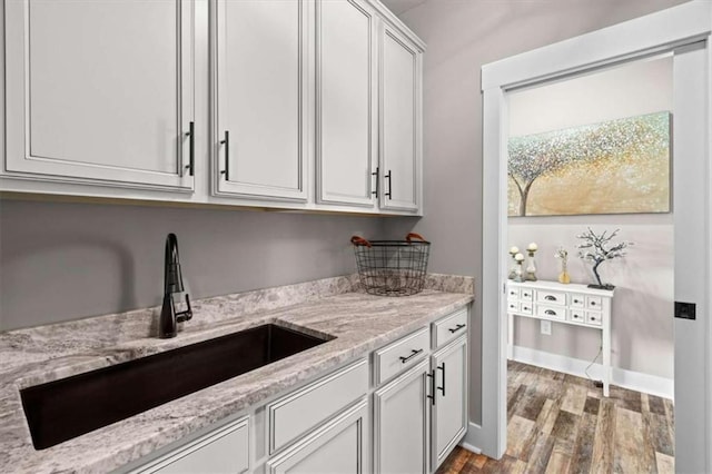 1423 Hillcrest Rd, Bowdon, GA 30108 - kitchen featuring a sink, wood finished floors, light stone countertops, and white cabinets