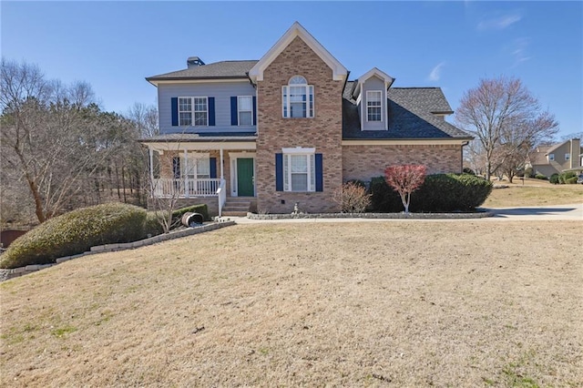 view of front of home with covered porch, brick siding, and a front lawn