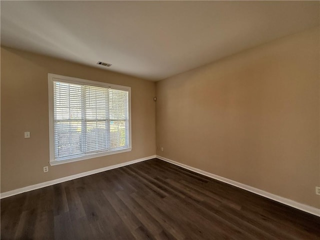 2728 Sandalwood Cir, Locust Grove, GA 30248 - empty room with dark wood finished floors, baseboards, and visible vents