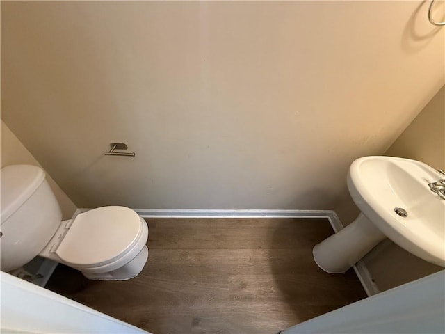 2728 Sandalwood Cir, Locust Grove, GA 30248 - half bathroom with a sink, baseboards, toilet, and wood finished floors