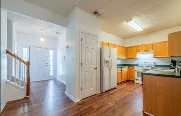 kitchen with a textured ceiling, decorative light fixtures, white appliances, and dark wood-type flooring