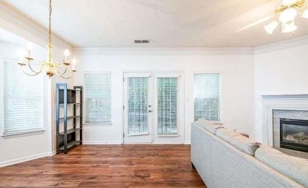 living room with dark hardwood / wood-style floors, ornamental molding, and ceiling fan with notable chandelier