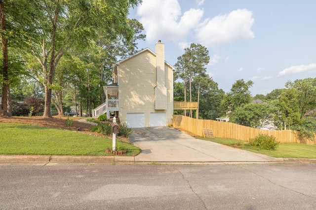 422 Inwood Trl, Lawrenceville, GA 30043 - view of side of home with concrete driveway, stairs, a garage, and a chimney