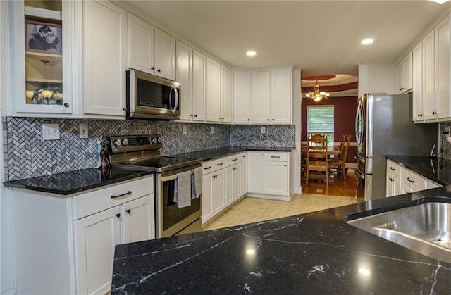 kitchen featuring stainless steel appliances, white cabinets, and decorative backsplash