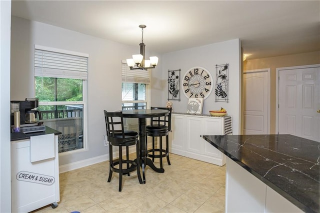 dining space featuring baseboards and an inviting chandelier