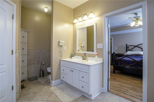 ensuite bathroom featuring a ceiling fan, toilet, ensuite bathroom, tile patterned flooring, and vanity