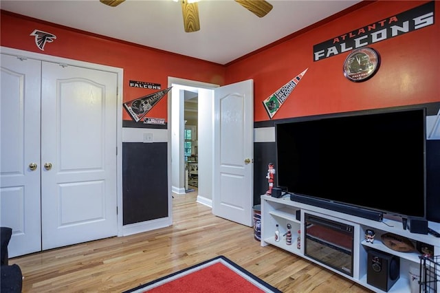 rec room featuring ceiling fan, ornamental molding, wood finished floors, and baseboards