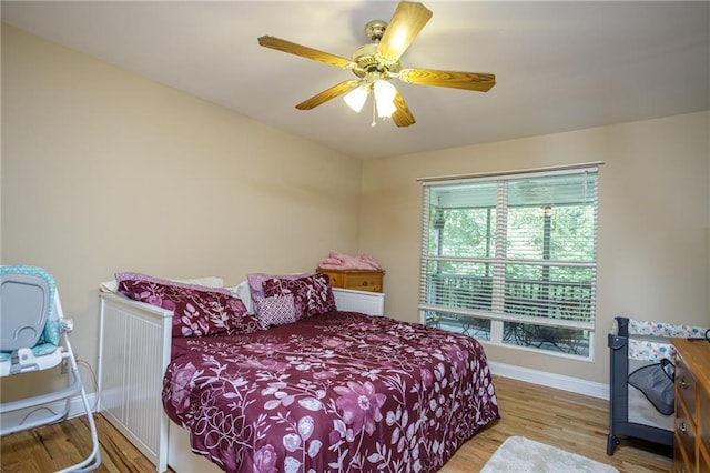 bedroom with a ceiling fan, baseboards, and wood finished floors