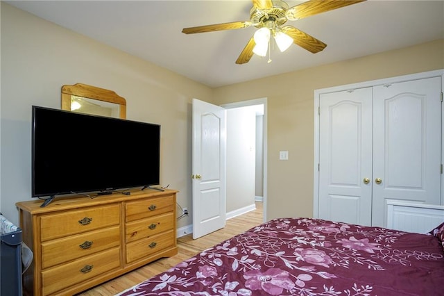 bedroom featuring baseboards, a closet, light wood-style flooring, and a ceiling fan