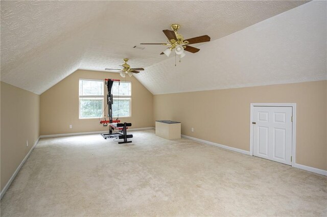 bonus room with lofted ceiling, visible vents, light carpet, a textured ceiling, and baseboards