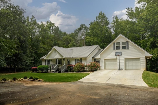 view of front of property with a porch, metal roof, driveway, and a front lawn