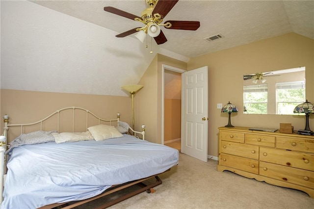 bedroom featuring lofted ceiling, a textured ceiling, light colored carpet, a ceiling fan, and visible vents