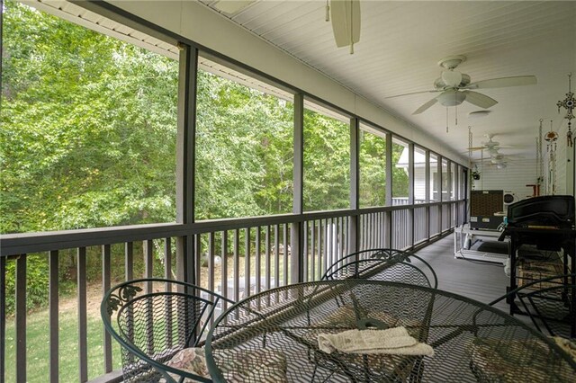 sunroom / solarium featuring a ceiling fan