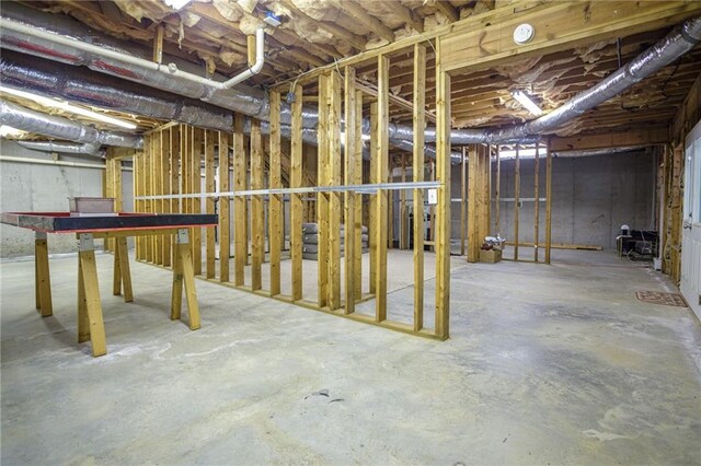 basement with stairway and freestanding refrigerator