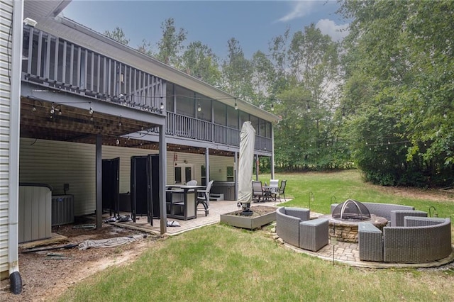 rear view of house with an outdoor fire pit, a patio area, and a yard