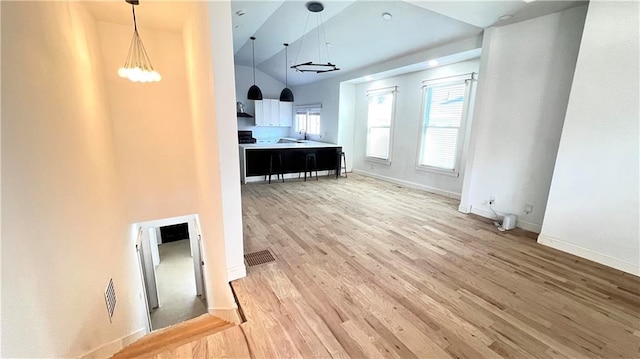 interior space featuring hardwood / wood-style floors, high vaulted ceiling, and sink