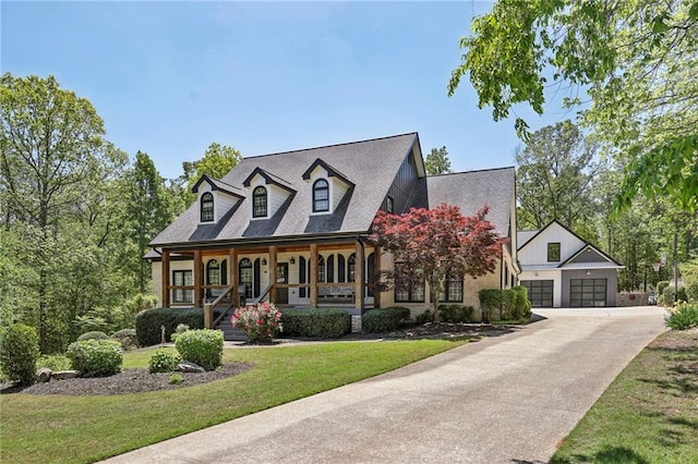 cape cod house featuring covered porch, a front lawn, and a garage