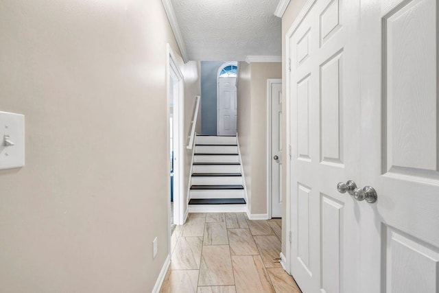 stairs featuring crown molding and a textured ceiling